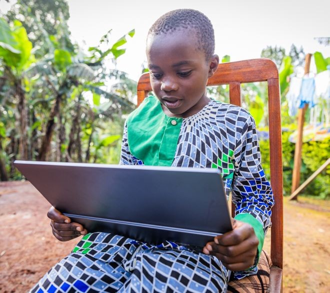 Child learning with a tablet in a rural area, reflecting the transformative impact of digital education promoted by the CADED foundation to close gaps and build a just future.