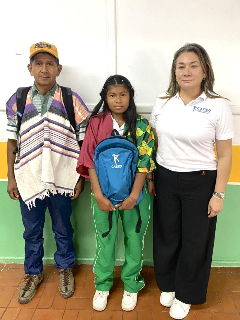 Niña concentrada estudiando con un portátil en una biblioteca, simbolizando el poder de la educación digital que CADED lleva a comunidades vulnerables como un verdadero héroe.